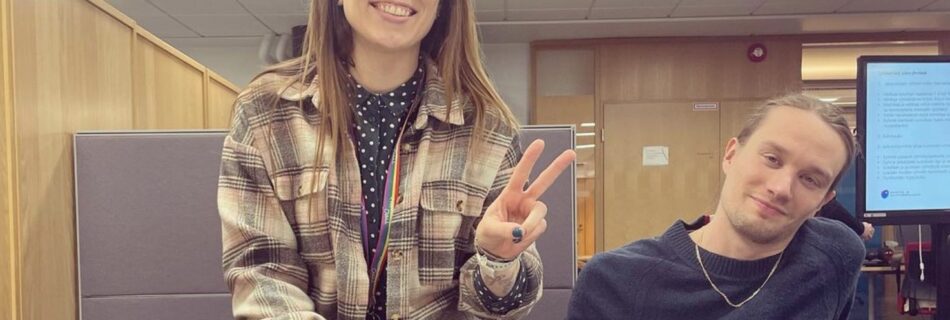 two young people in an office environment, smiling and relaxed